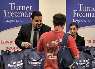 Fady from Turner Freeman Lawyers handing out merchandise