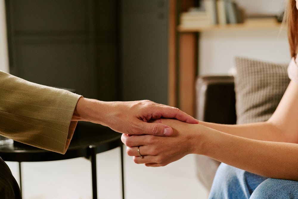 middle,aged,caucasian,woman,holding,hand,of,young,adult,caucasian