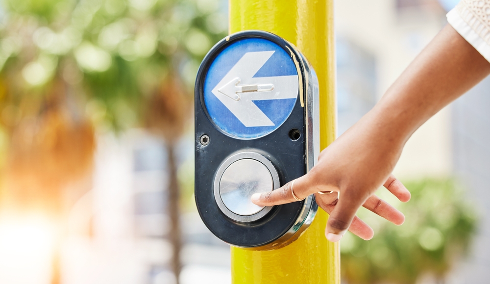 crosswalk,,arrow,and,button,with,hand,of,woman,in,city
