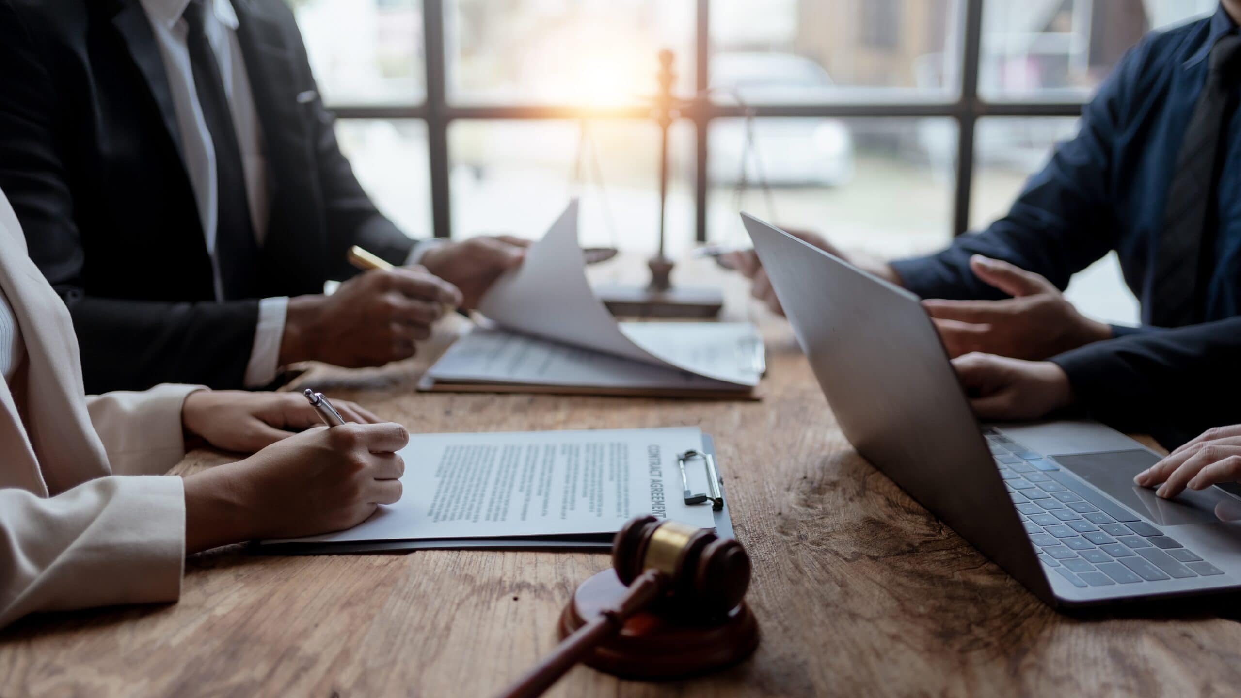 people with paperwork and a laptop having a discussion
