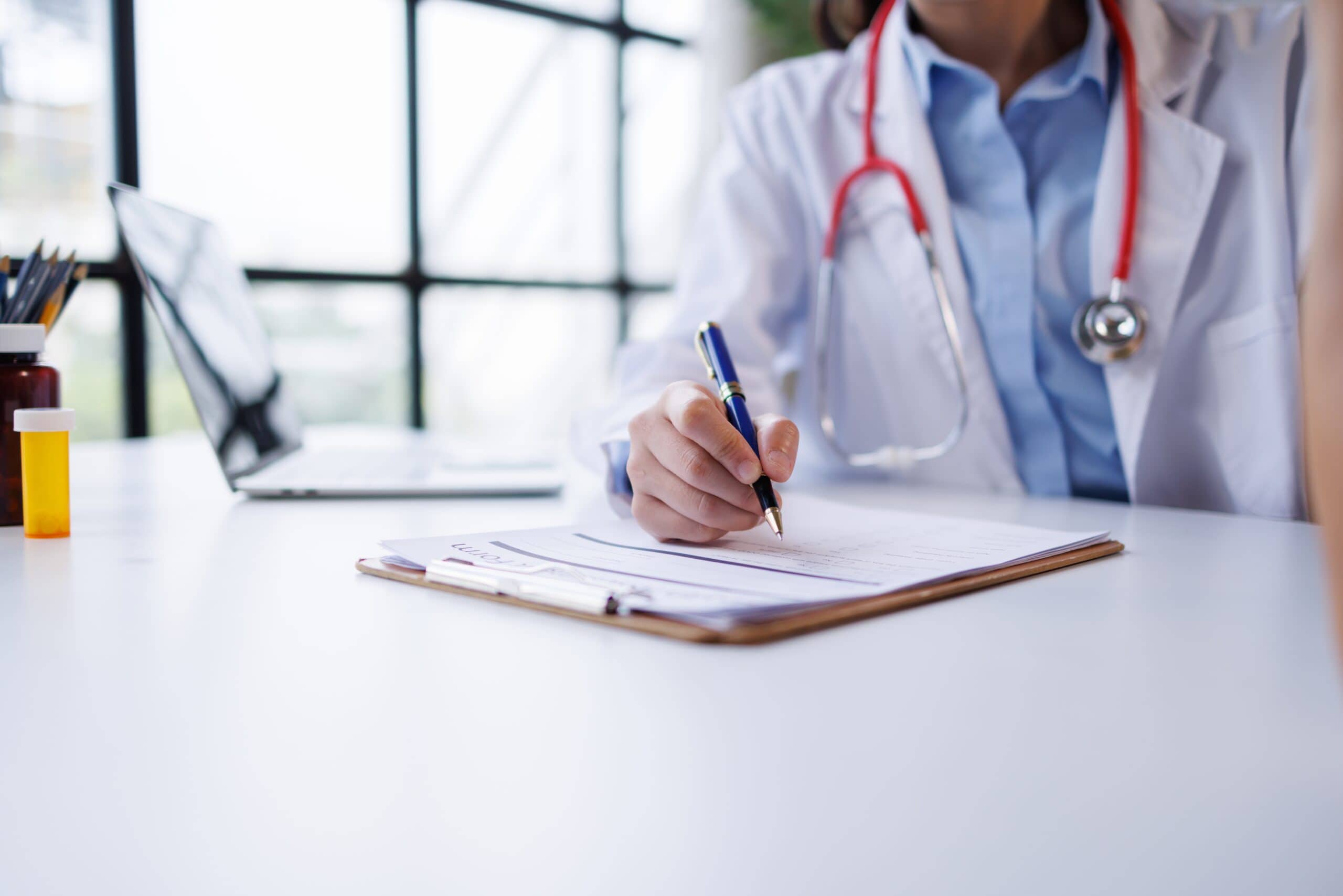 doctor,writing,prescription,or,medical,notes,during,patient,consultation,,working